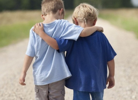 Two brothers walking with arms around eachother